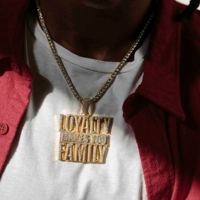 Black mail in white tee shirt wearing tennis chain with a iced-out yellow gold pendant reading loyalty makes you family